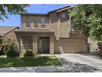 Inviting two-story home featuring a stone facade, a two-car garage, and a charming balcony, nestled in a tranquil neighborhood at 4366 E Lexington Ave, Gilbert, AZ 85234
