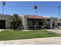 Charming single-story home featuring a well-manicured lawn, decorative privacy screen, and a classic tile roof at 8343 E San Ricardo Dr, Scottsdale, AZ 85258