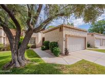 Charming one-story home featuring stucco siding, lush green lawn, mature landscaping, and a two-car garage at 9128 W Kimberly Way, Peoria, AZ 85382