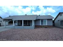 Charming single-story home featuring a covered front porch and low-maintenance rock landscaping at 1033 S Florence Dr, Mesa, AZ 85208