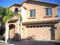 Two-story home featuring a spacious garage, complemented by a well-maintained front yard and architectural detail at 1084 E Saddleback Pl, San Tan Valley, AZ 85143