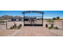 Dramatic entrance to Rancho Los Ramos with a wrought iron gate, decorative stone accents and paver entry at 10910 N Thunderbird Rd, Maricopa, AZ 85139