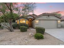 Charming single-story home with desert landscaping, red tile roof, and inviting curb appeal at dusk at 14945 N 102Nd St, Scottsdale, AZ 85255