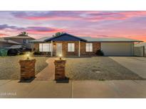 Charming brick home with a well-manicured yard under a breathtaking sunset sky at 1511 E Harmony Ave, Mesa, AZ 85204