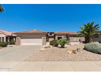 Charming single-story home boasts a low-maintenance landscape, tile roof, and attached two-car garage at 20394 N Coronado Way, Surprise, AZ 85374