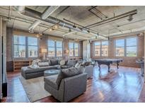 Expansive living room boasting exposed ductwork, brick walls, a pool table, and lots of natural light from numerous windows at 21 E 6Th St # 316, Tempe, AZ 85281