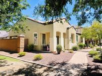 Inviting single-story home featuring a cozy front porch, brick accents, and desert landscaping at 2554 E Vermont Dr, Gilbert, AZ 85295