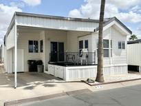 Charming mobile home featuring a covered porch with outdoor seating and tidy, low maintenance landscaping at 272 S Cinnabar Dr, Apache Junction, AZ 85119