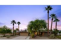 Charming single-story home with desert landscaping and mature palm trees at dusk at 3146 W Paradise Dr, Phoenix, AZ 85029