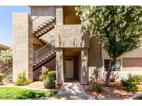 Multi-level condo complex featuring stucco siding, metal stairs, and mature landscaping near the front entrance at 3830 E Lakewood Pkwy # 1057, Phoenix, AZ 85048