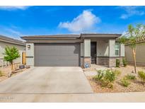 Charming single-story home featuring a well-maintained front yard and a two-car garage, with stone accents and neutral paint at 4701 S Siphon Draw Rd, Apache Junction, AZ 85119