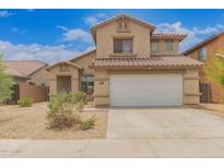 Charming two-story home with a well-maintained front yard, a two-car garage and a tile roof at 5123 W Novak Way, Laveen, AZ 85339