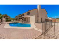 Home's backyard featuring a refreshing pool, outdoor seating area, and well-kept landscaping at 6101 W Sunnyside Dr, Glendale, AZ 85304