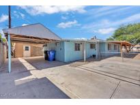 Exterior shows a blue house with covered parking, a large concrete driveway, and a chain link fence at 6447 W Piccadilly Rd, Phoenix, AZ 85033