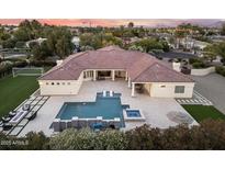 Aerial view of a backyard featuring a pool, spa, and outdoor seating area with mature landscaping at 7129 E Caron Dr, Paradise Valley, AZ 85253