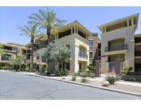 Multi-level building with neutral-colored exterior, balconies, palm trees, and well-maintained landscaping at 7601 E Indian Bend Rd # 1049, Scottsdale, AZ 85250