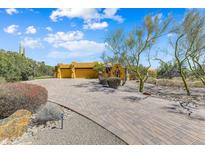 Attractive Southwestern-style home featuring a circular driveway and desert landscaping at 9415 N 124Th St, Scottsdale, AZ 85259
