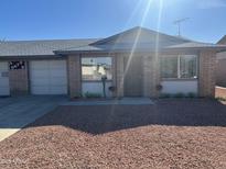 Charming single-story home featuring desert landscaping, brick facade, and attached garage, perfect for comfortable living at 9679 W Cinnabar Ave # B, Peoria, AZ 85345