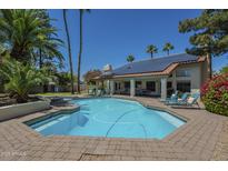 Enjoy this large backyard pool surrounded by lounge chairs, palm trees, and lush landscaping at 12537 N 76Th Pl, Scottsdale, AZ 85260