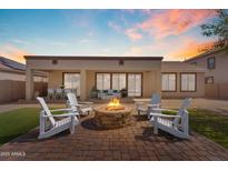 Inviting backyard featuring a stone fire pit and patio furniture, perfect for relaxation and entertaining at 15564 W Mescal St, Surprise, AZ 85379