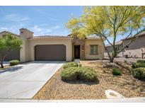 Charming single-story home featuring a neutral-toned exterior, landscaped front yard, and attached two-car garage at 16913 W Holly St, Goodyear, AZ 85395