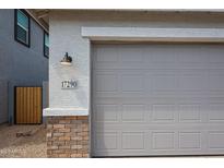 Close up of a large two car garage and lovely brick accent at 17290 W Daley Ln, Surprise, AZ 85387