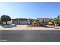 Charming single-story home featuring a three-car garage and desert landscaping for low maintenance at 21003 N Circle Cliffs Dr, Surprise, AZ 85387
