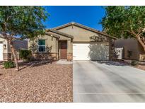 Charming single-story home with a well-maintained front yard and attached two-car garage at 36203 N Urika Dr, San Tan Valley, AZ 85140