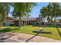 Charming single-story home with lush green lawn and mature trees in a well-maintained neighborhood at 4711 S Los Feliz Dr, Tempe, AZ 85282