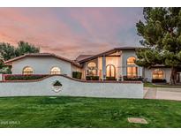 Stunning single-Gathering home boasts a mature landscape, lush lawn, and charming brick-accented retaining wall at 5602 W Alameda Rd, Glendale, AZ 85310