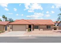 Charming single-story home featuring a tile roof, desert landscaping, and a two-car garage at 5852 E Enrose St, Mesa, AZ 85205