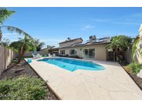 Relaxing backyard featuring a refreshing pool, lush landscaping, and comfortable seating under a clear blue sky at 6101 W Grandview Rd, Glendale, AZ 85306