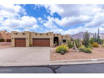 Charming Santa Fe home boasts a desert landscaped yard and two-car garage at 9938 E Little Nugget Way, Gold Canyon, AZ 85118