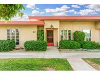 Inviting single-story home with desert landscaping and a red front door at 10040 W Royal Oak Rd # N, Sun City, AZ 85351