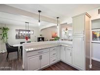 Bright kitchen featuring grey cabinets, granite countertops, and an open design to the adjacent dining area at 1210 W Missouri Ave, Phoenix, AZ 85013