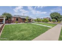 Charming brick home with lush lawn and modern walkway, offering great curb appeal at 1551 W Vernon Ave, Phoenix, AZ 85007