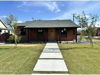 Charming brick home with a well-manicured lawn and modern concrete walkway, creating great curb appeal at 1551 W Vernon Ave, Phoenix, AZ 85007