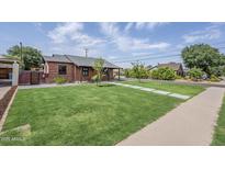Well-manicured front yard with lush lawn, updated landscaping, and charming curb appeal at 1551 W Vernon Ave, Phoenix, AZ 85007