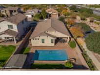 Aerial view of a backyard oasis with a refreshing pool, covered patio, and well-maintained landscaping and fencing at 20765 E Raven Dr, Queen Creek, AZ 85142