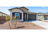 Charming home featuring stone accents, a two-car garage, and a low-maintenance desert landscape at 23417 W Burton Ave, Buckeye, AZ 85326