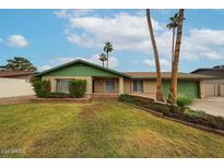 Charming single-story home features a lush front lawn, brick accents, and mature palm trees, creating a welcoming curb appeal at 4530 W Larkspur Dr, Glendale, AZ 85304