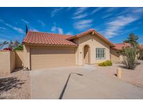 Tan single-story home with a red tile roof, two-car garage, and desert landscaping under a sunny, blue sky at 4538 E Shomi St, Phoenix, AZ 85044