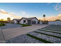 Stunning home featuring a three-car garage and decorative driveway and gate at 5922 W Michelle Dr, Glendale, AZ 85308