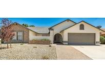 Charming single-story home featuring a two-car garage and low-maintenance desert landscaping in front at 6601 W Montego Ln, Glendale, AZ 85306