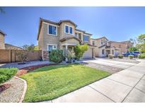 Charming two-story home featuring a well-manicured lawn, desert landscaping, and a spacious driveway at 6811 W Darrel Rd, Laveen, AZ 85339