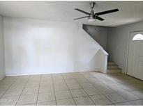 Bright living room featuring tile floors and a modern ceiling fan at 6901 W Mackenzie Dr # 1287, Phoenix, AZ 85033