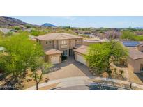 An attractive two-story home showcases a terracotta tile roof, desert landscaping, and a paver driveway with a three-car garage at 8830 S 20Th S Pl, Phoenix, AZ 85042
