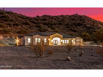 View of desert home with desert landscaping and mountain backdrop during a colorful sunset at 9357 W Canyon Verde Dr, Casa Grande, AZ 85194
