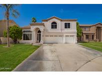 Charming two-story home with a three car garage, well-manicured lawn, and an arched entryway at 1014 W Mulberry Dr, Chandler, AZ 85286