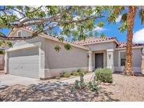 Charming single-story home with a two-car garage, desert landscaping and a red tile roof at 15802 W Watson Ln, Surprise, AZ 85379